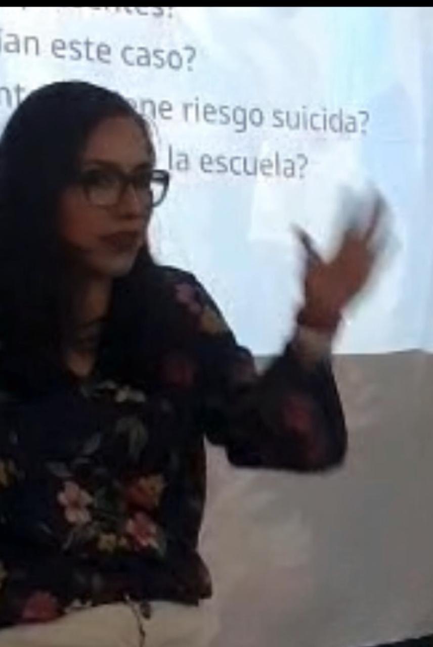 La Dra. Cruz Gómez imparte clase frente a una presentación